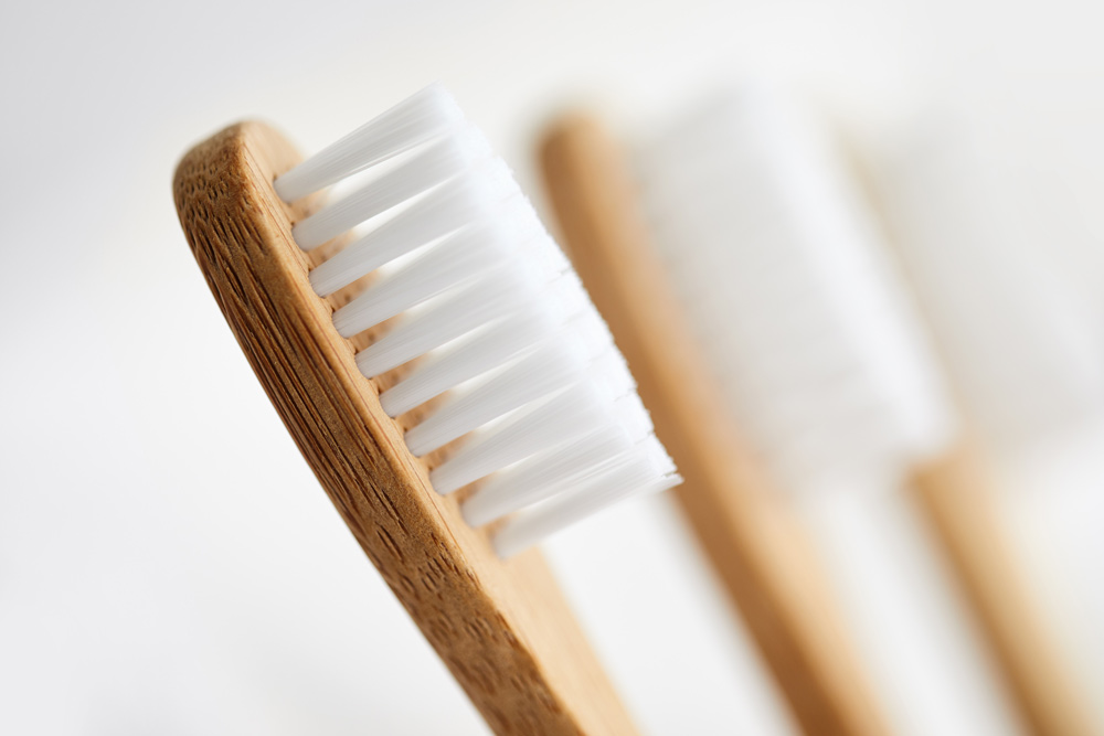 Close up of three bamboo toothbrushes on white background